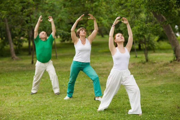 group of people practice Tai Chi Chuan in a park