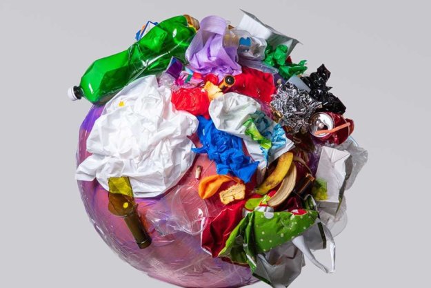 A globe of the earth with trash over white background, the concept of ecology problem A globe of the earth with trash over white background, the concept of ecology problem and World Environment Day. Photo with message for social advertising, place for inscription