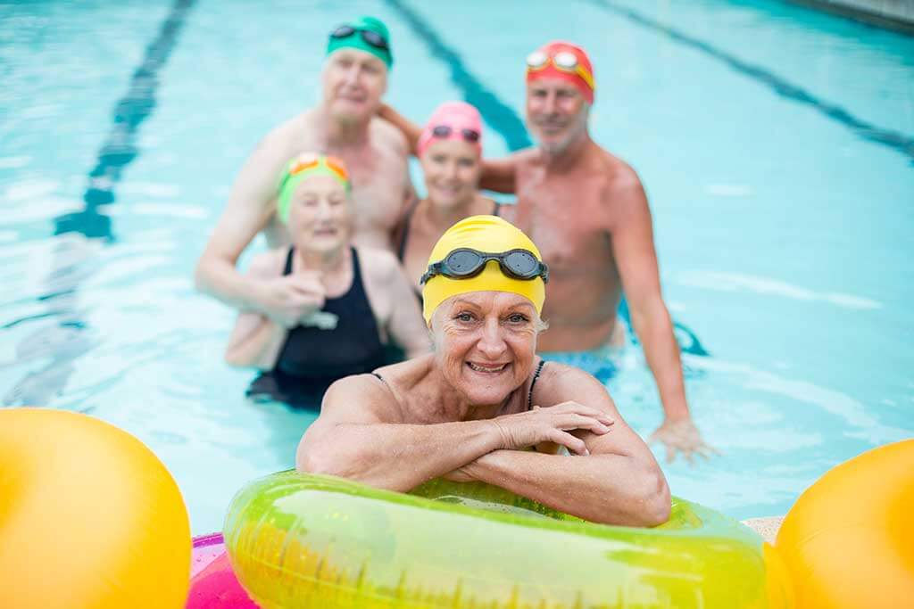 Senior woman by inflatable rings with friends