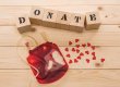 Top view of blood bag and wooden cubes with word donate, donation concept