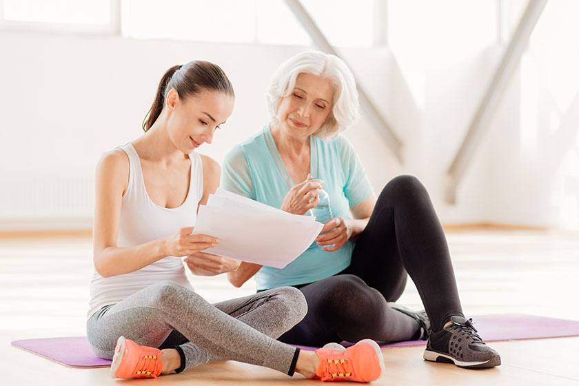 Attractive positive woman holding a fitness program Attractive positive woman holding a fitness program