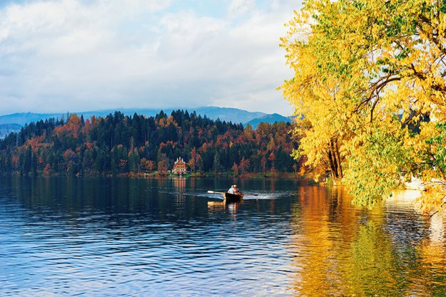 Beautiful landscape of Bled Lake and senior people in boat Beautiful landscape of Bled Lake and senior people in boat