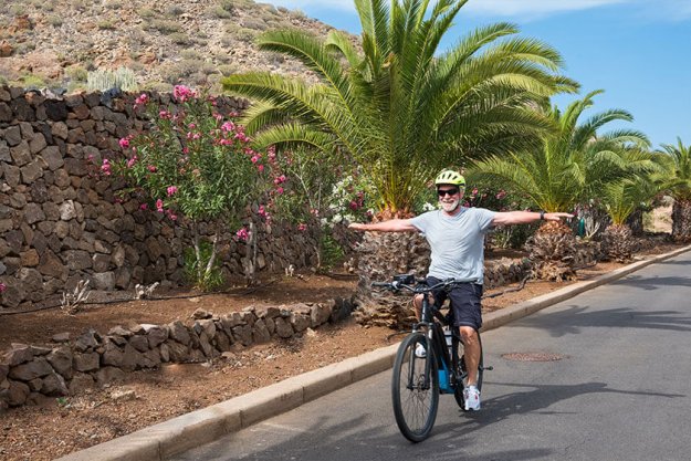 Caucasian grandfather riding with an e bike Caucasian grandfather riding with an e bike