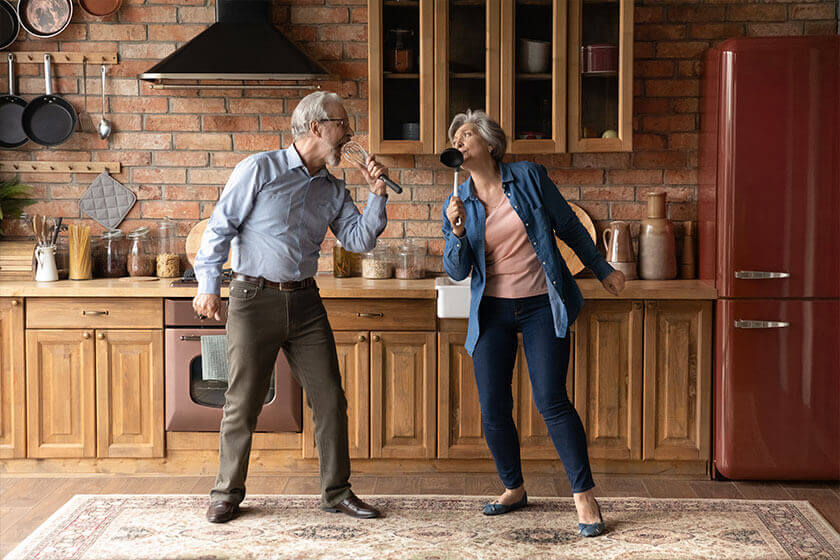Happy older senior loving family couple having fun in kitchen