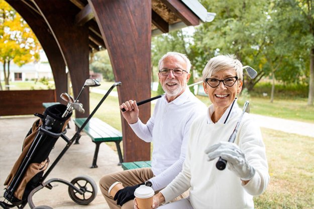 Portrait of senior people in retirement holding golf clubs and ready for golf training Portrait of senior people in retirement holding golf clubs and ready for golf training