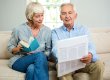 Senior couple reading newspaper at home