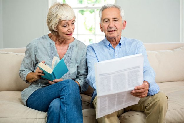 Senior couple reading newspaper at home Senior couple reading newspaper at home