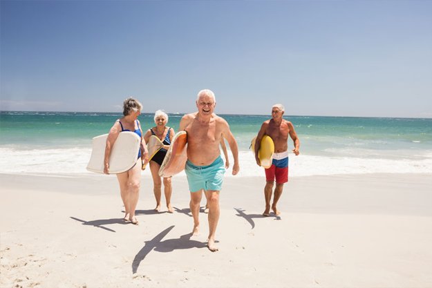 Senior friends holding surfboard Senior friends holding surfboard