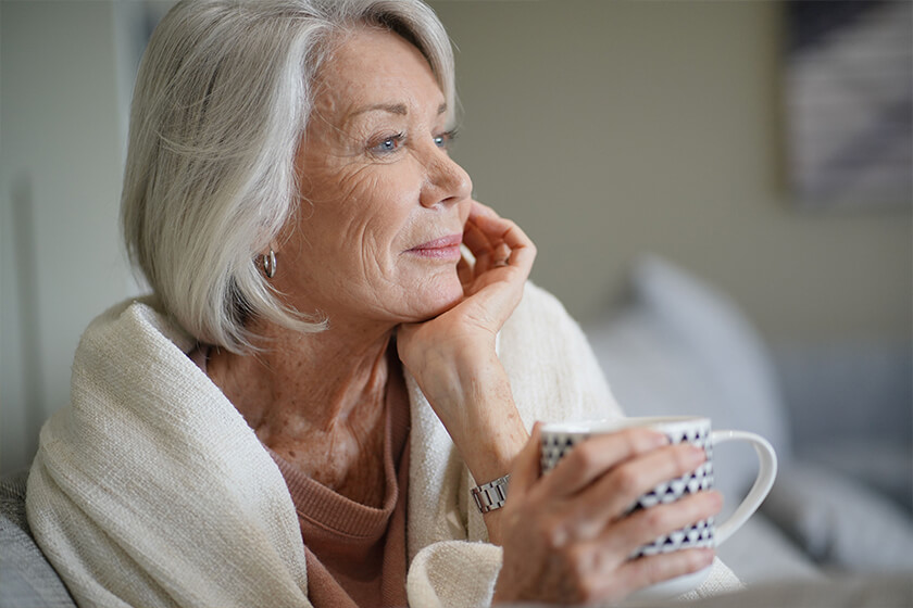 Cosy looking senior woman at home with hot drink Cosy looking senior woman at home with hot drink