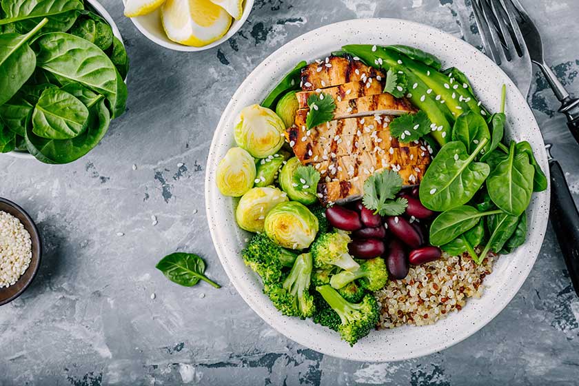 Healthy buddha bowl lunch with grilled chicken, quinoa, spinach, avocado, brussels sprouts, broccoli, red beans with sesame seeds Healthy buddha bowl lunch with grilled chicken, quinoa, spinach, avocado, brussels sprouts, broccoli, red beans with sesame seeds