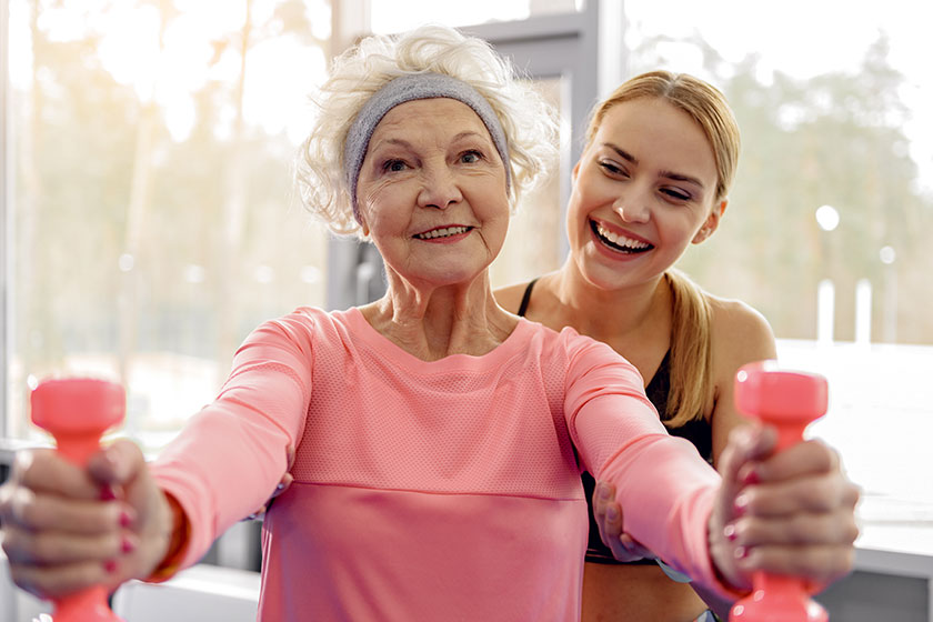 Cheerful grandmother making exercises in gym Cheerful grandmother making exercises in gym