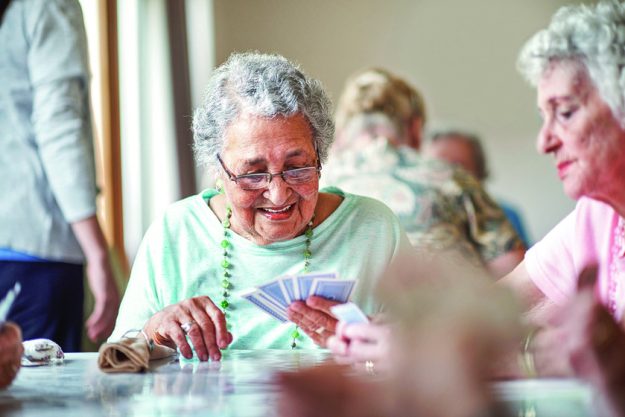 Shot of a group of seniors playing a board game in their retirement home Shot of a group of seniors playing a board game in their retirement home