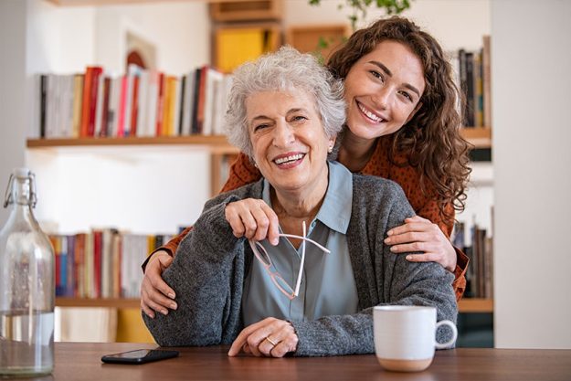 Happy granddaughter embracing senior grandmother Happy granddaughter embracing senior grandmother