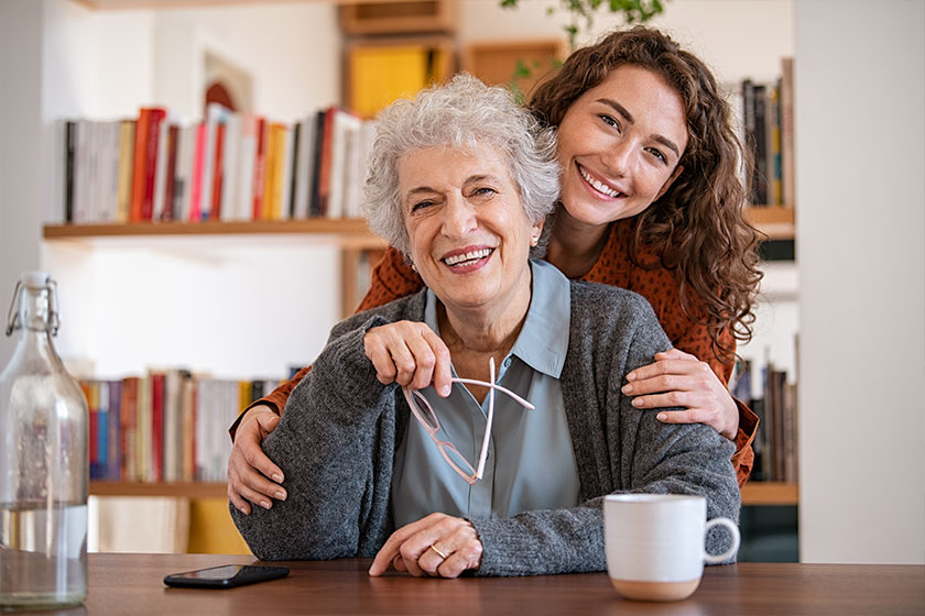 Happy granddaughter embracing senior grandmother