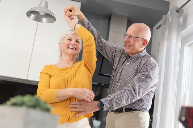 Senior couple dancing and smiling at home Senior couple dancing and smiling at home