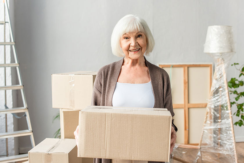 Cheerful senior woman holding cardboard box Cheerful senior woman holding cardboard box