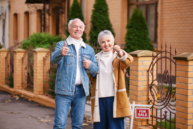 senior-couple-with-key-near-their-new-house senior-couple-with-key-near-their-new-house