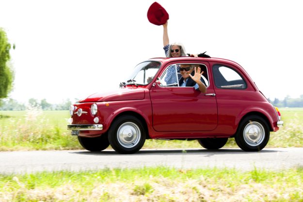 Senior couple driving vintage car