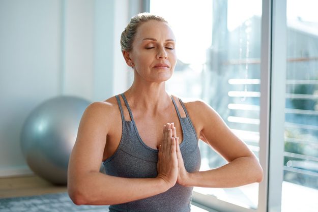 In perfect balance. an attractive mature woman  meditation home In perfect balance. an attractive mature woman meditation home