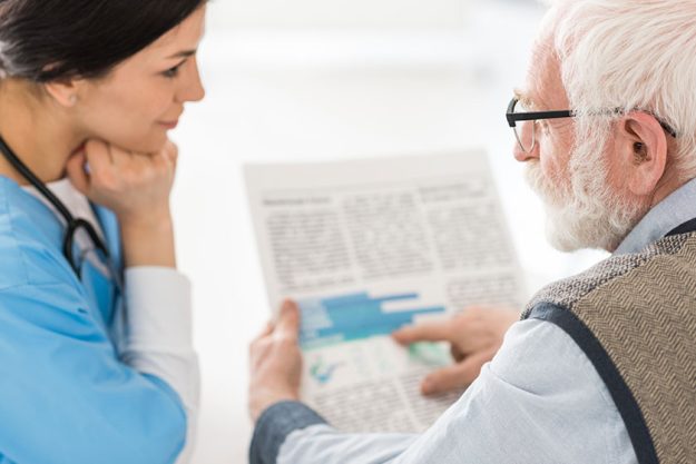 Selective focus of grey haired man talking with nurse