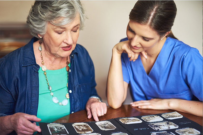 This one takes me back…a resident and a nurse looking through a photo album This one takes me back...a resident and a nurse looking through a photo album