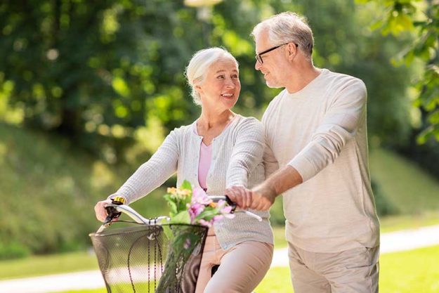 Happy senior couple with bicycle at summer park Happy senior couple with bicycle at summer park