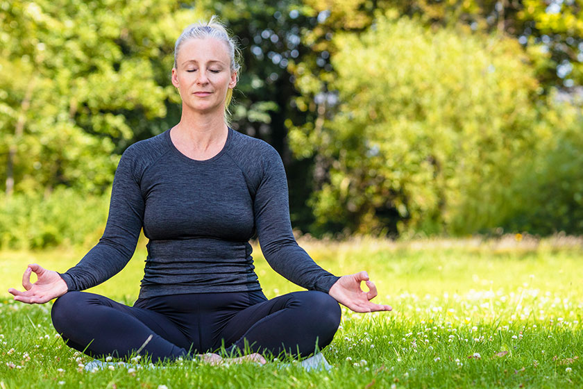Panoramic web banner header of mature middle aged fit healthy woman practicing yoga outsidein a natural tranquil green environment panorama. Panoramic web banner header of mature middle aged fit healthy woman practicing yoga outsidein a natural tranquil green environment panorama.