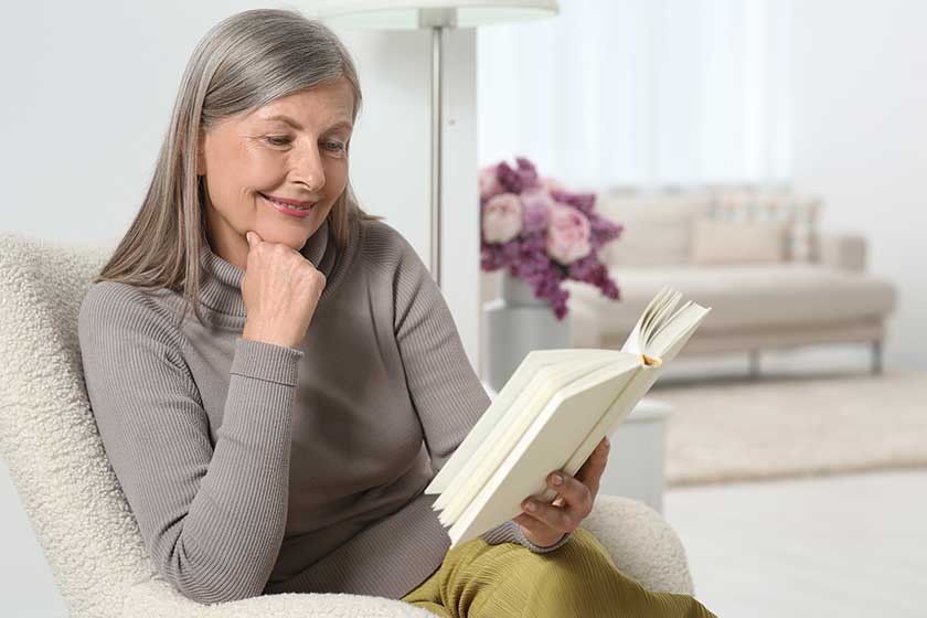 Beautiful-senior-woman-reading-book-armchair-home Beautiful-senior-woman-reading-book-armchair-home