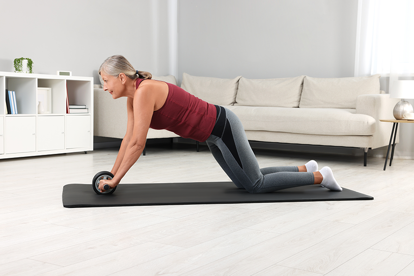 senior-woman-sportswear-exercising-abdominal-wheel