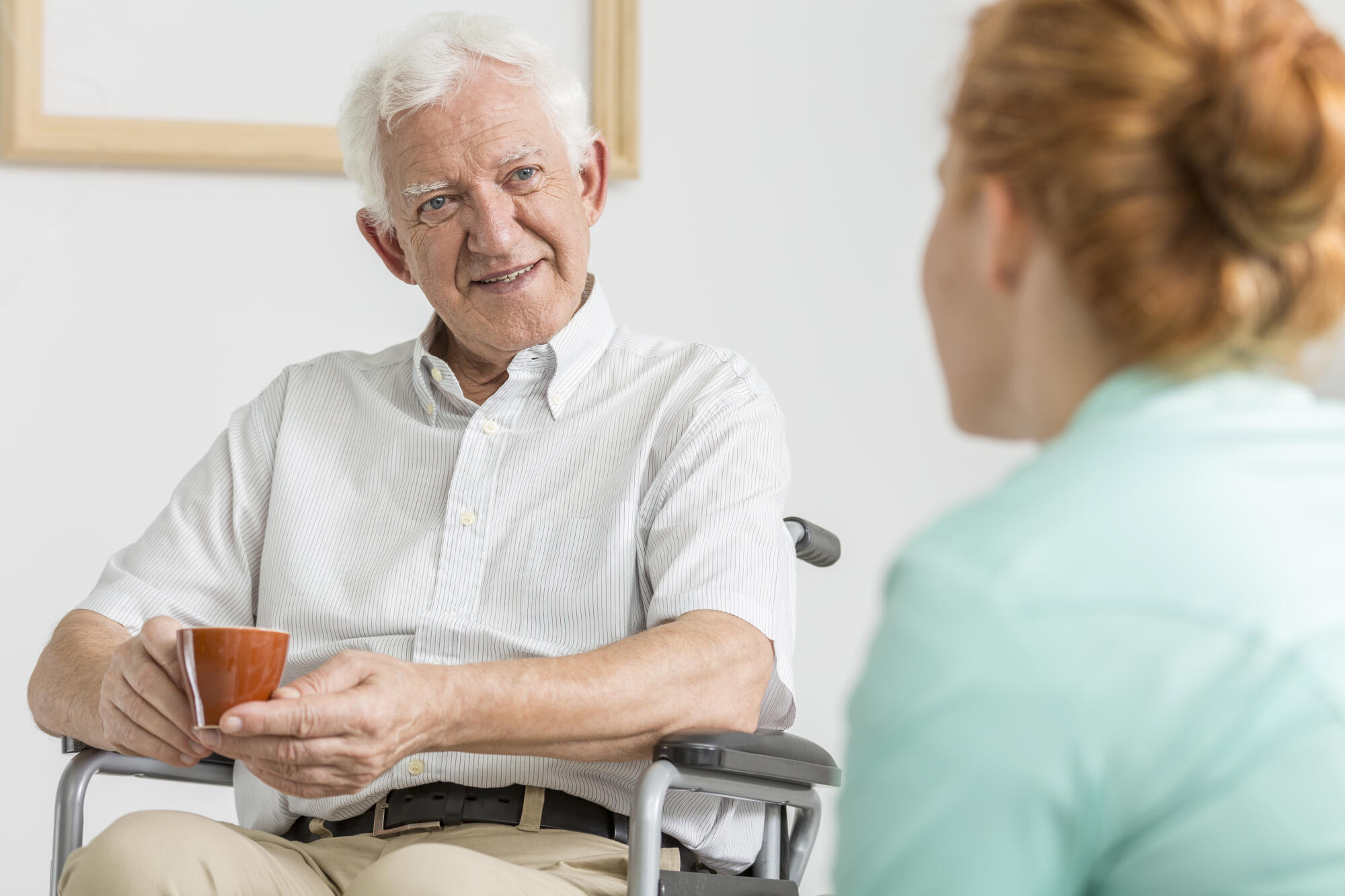 Elderly,Man,On,A,Wheelchair,Drinking,Coffee,With,His,Carer