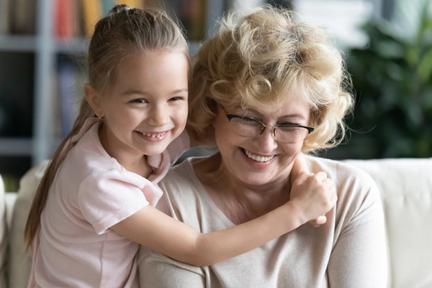 close-up-cute-smiling-little-girl-hugging-mature-grandmother