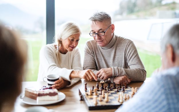 Group,Of,Senior,Friends,At,Home,,Playing,Board,Games.