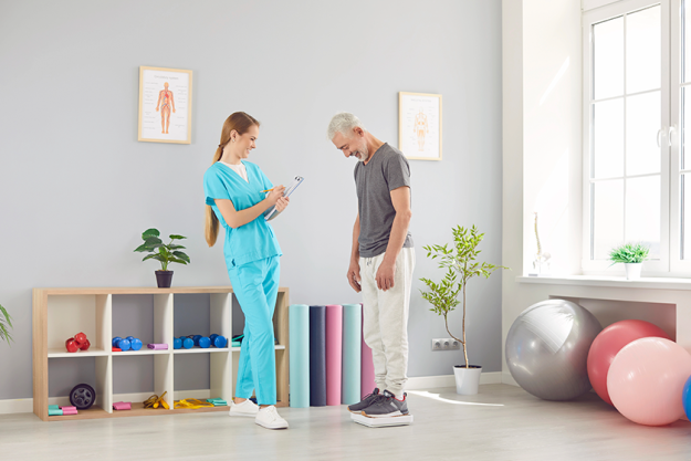 female-doctor-physiotherapist-nurse-weighing-senior-patient Female doctor physiotherapist or nurse weighing a senior patient