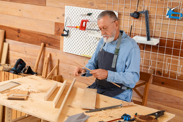 mature-carpenter-working-wooden-plank Mature carpenter working with wooden plank